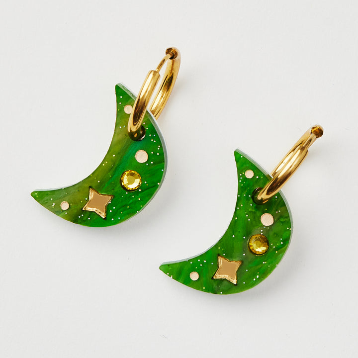 Green Moon earring with twinkling motifs and yellow crystal inlay hanging on a gold hoop 