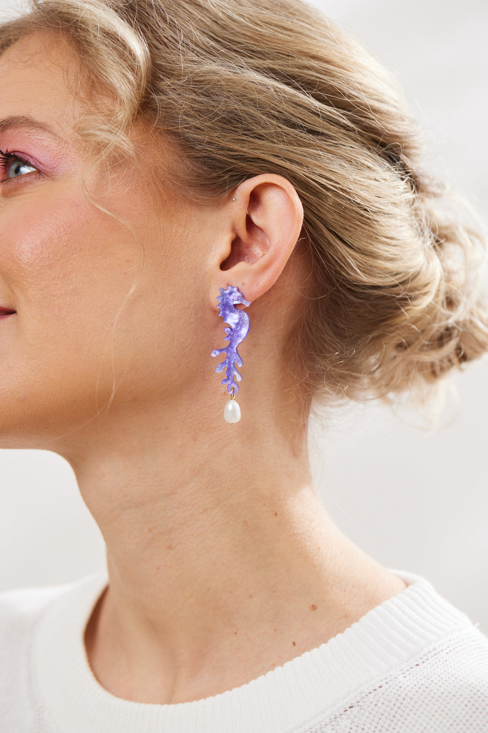 model wearing Sea Horse and Pearl earrings in Purple