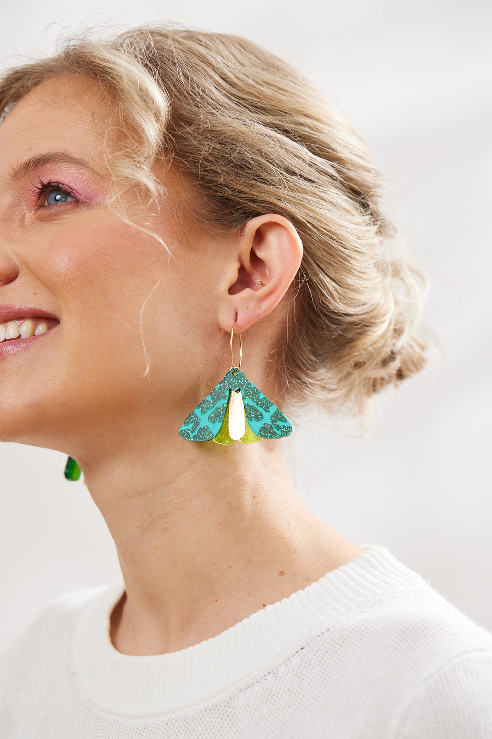 Martha Jean Moth earrings in Green Glitter model wearing them