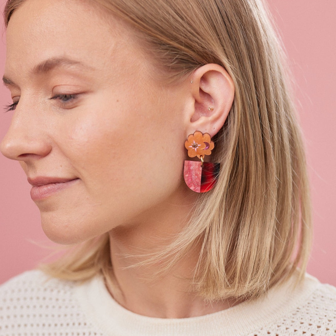 Orange and pink earrings on a model