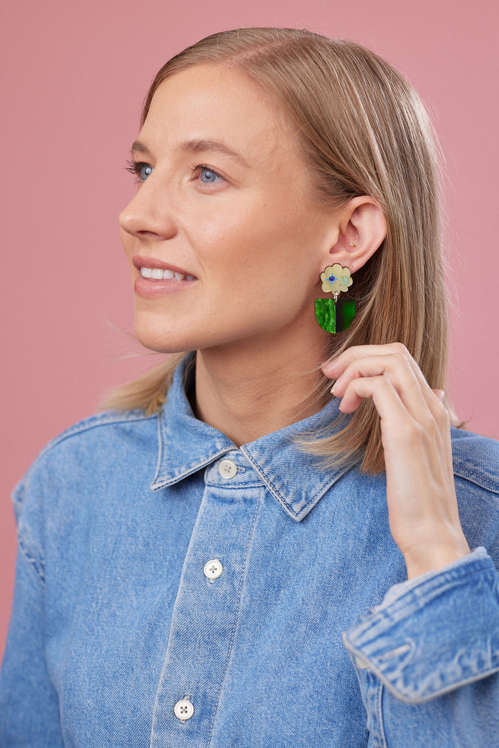 Model wearing green earrings.